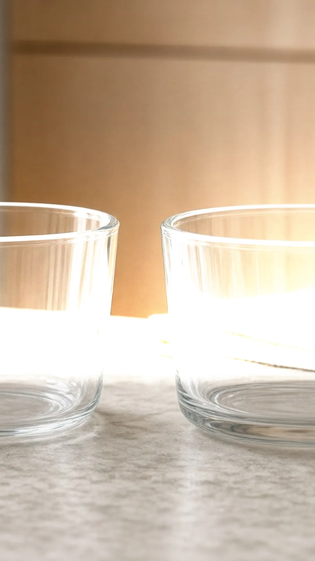 Two clear glass food containers side by side on a marble counter