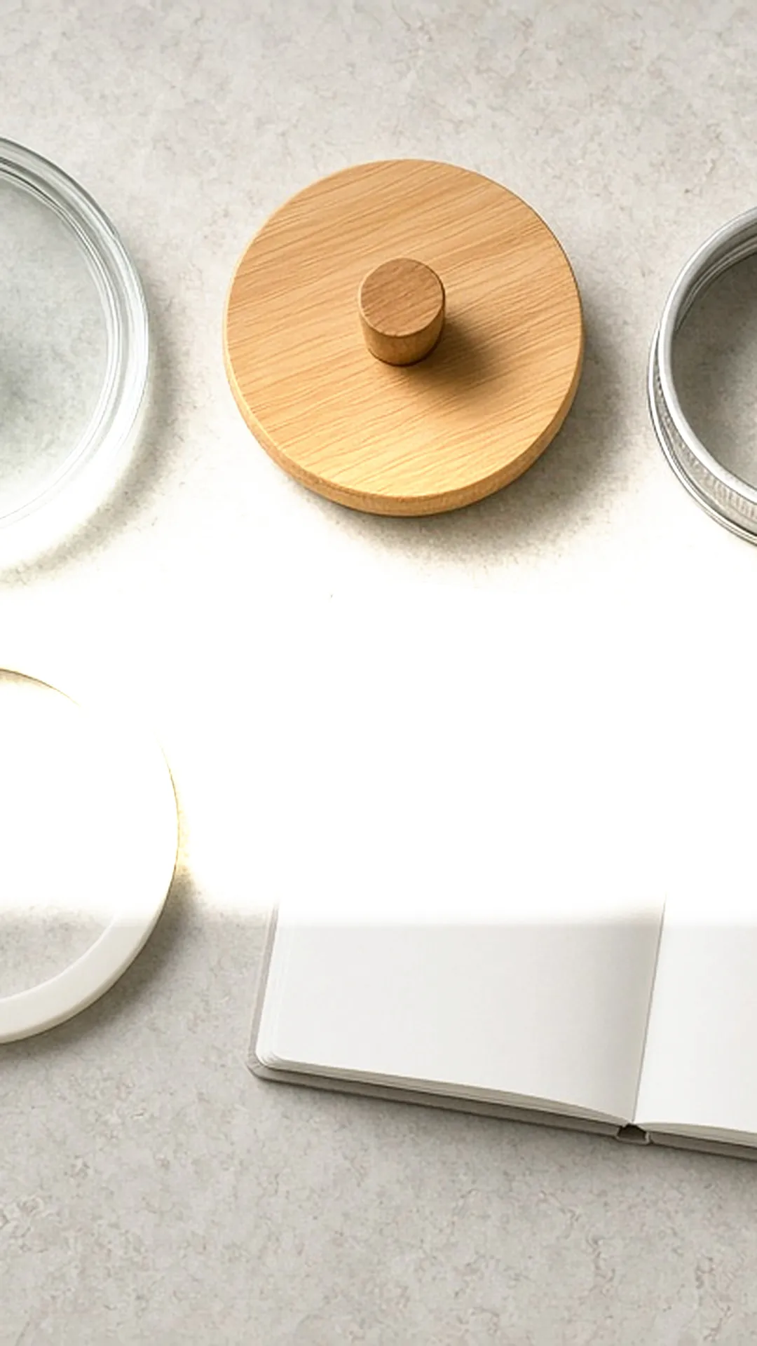 Glass container parts laid out with a notebook